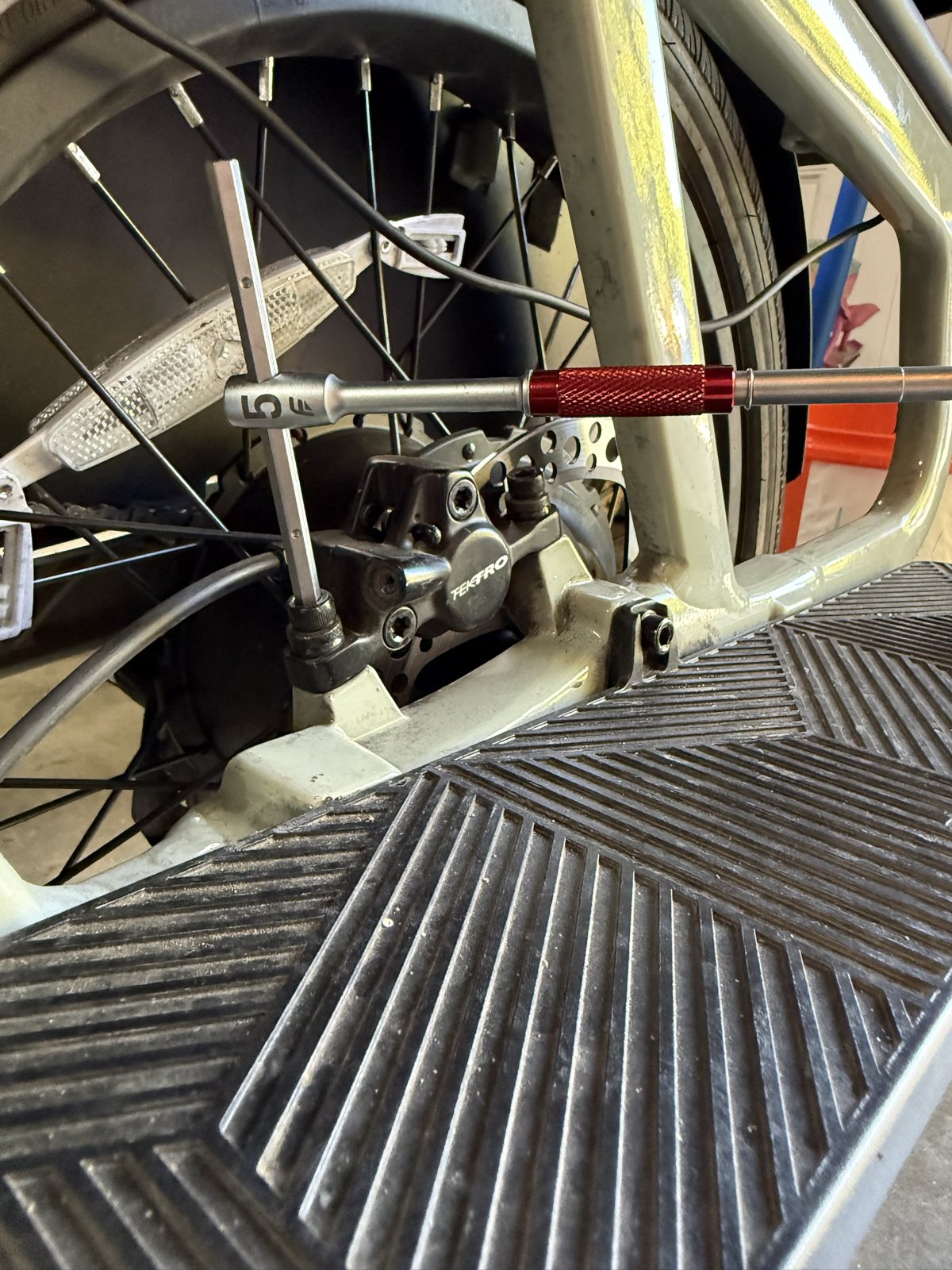 A 5 mm hex key on the rear Tektro brake caliper of an Aventon Abound