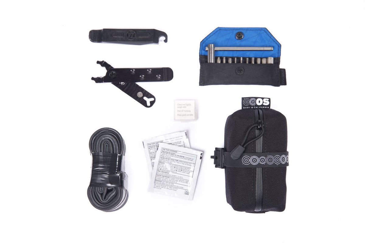 Outer Shell Mini Saddlebag, laid out with a tube, levers and tools it holds