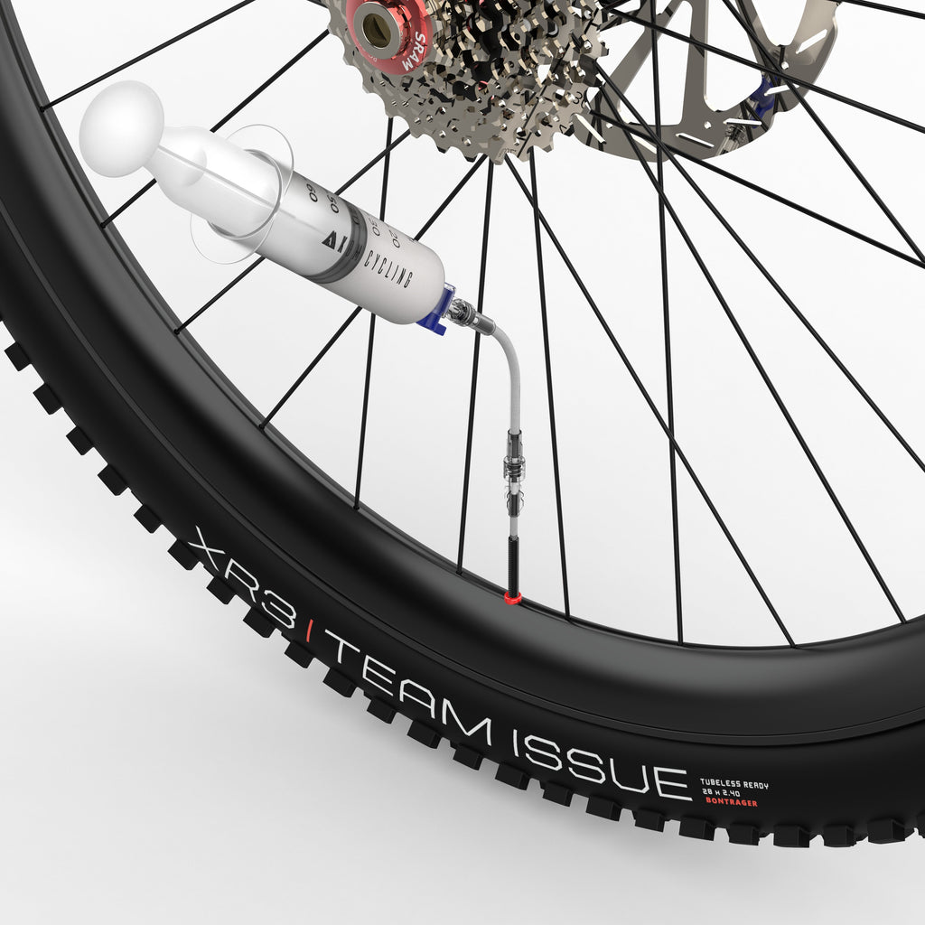 KOM Tubeless Sealant Injector, injecting sealant through the valve on a mountain bike wheel