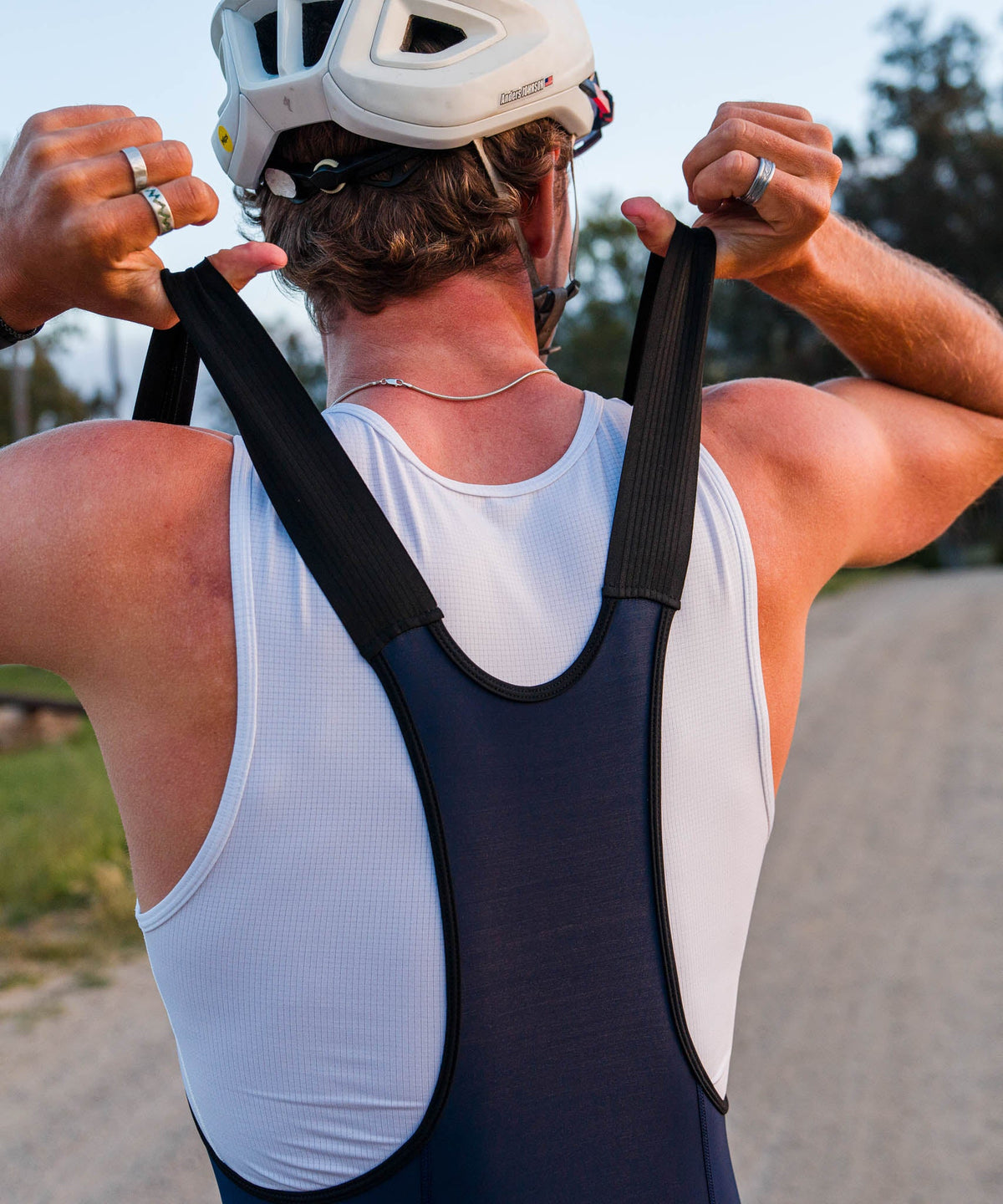Voler Men's Escape Bib, Black, rider pulling the bib straps on, back view