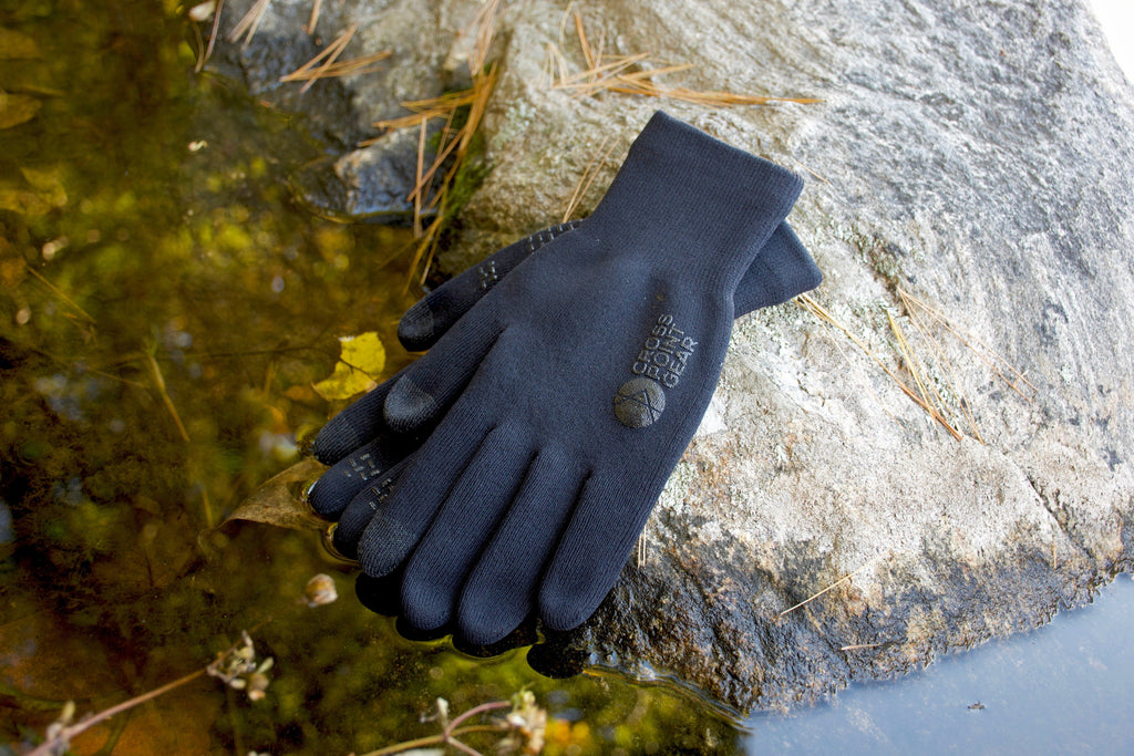 Cross Point Waterproof Knit Gloves: Sport, pair resting on a wet rock