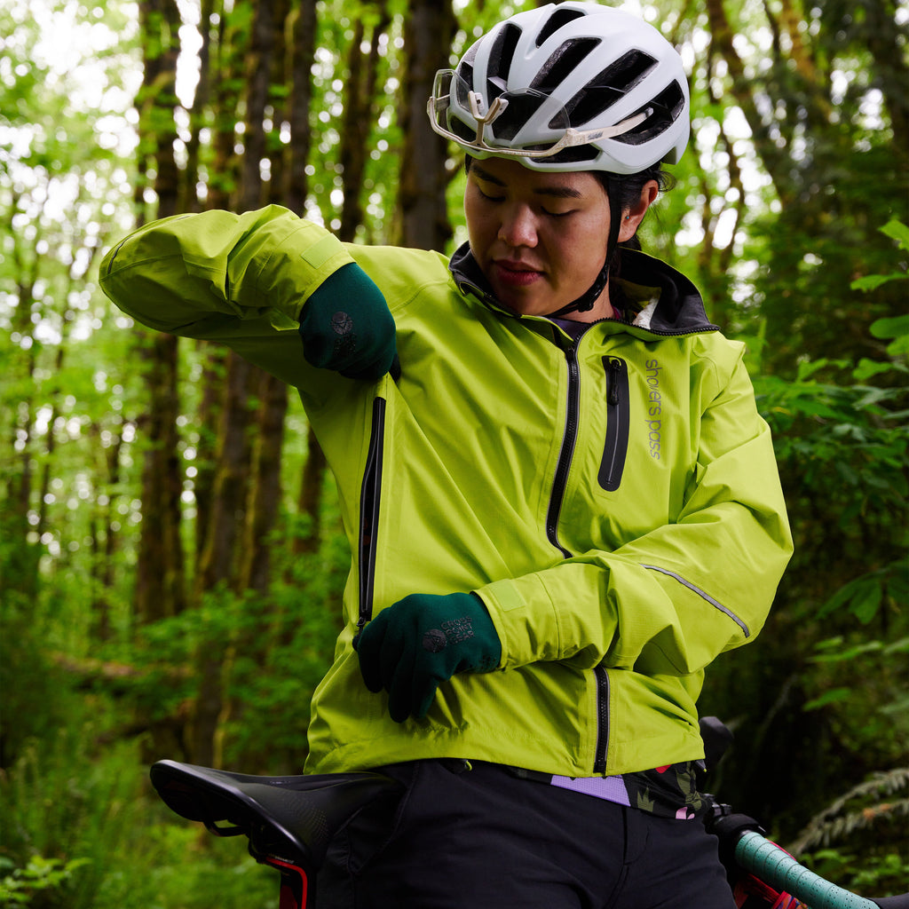 Women's Century Jacket, hi-vis yellow, rider reaching for the back pocket