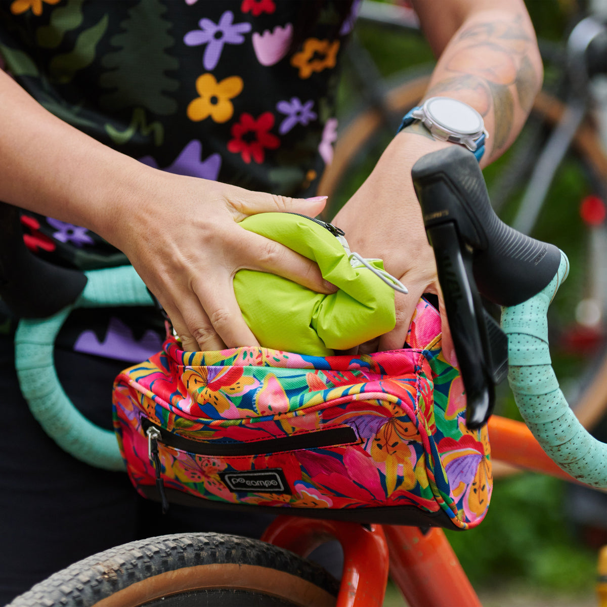 Women's Century Jacket, packed into its pocket, going into a handlebar bag