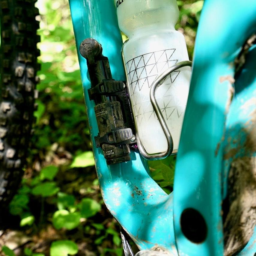 Wolf Tooth EnCase Pump 40cc, mounted next to a bottle cage on a teal frame