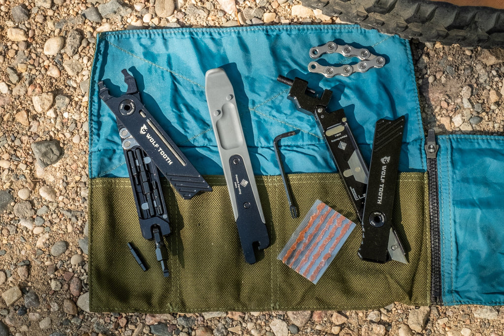 Wolf Tooth 8-Bit Tire Lever + Rim Dent Remover, laid out in a tool roll with other tools