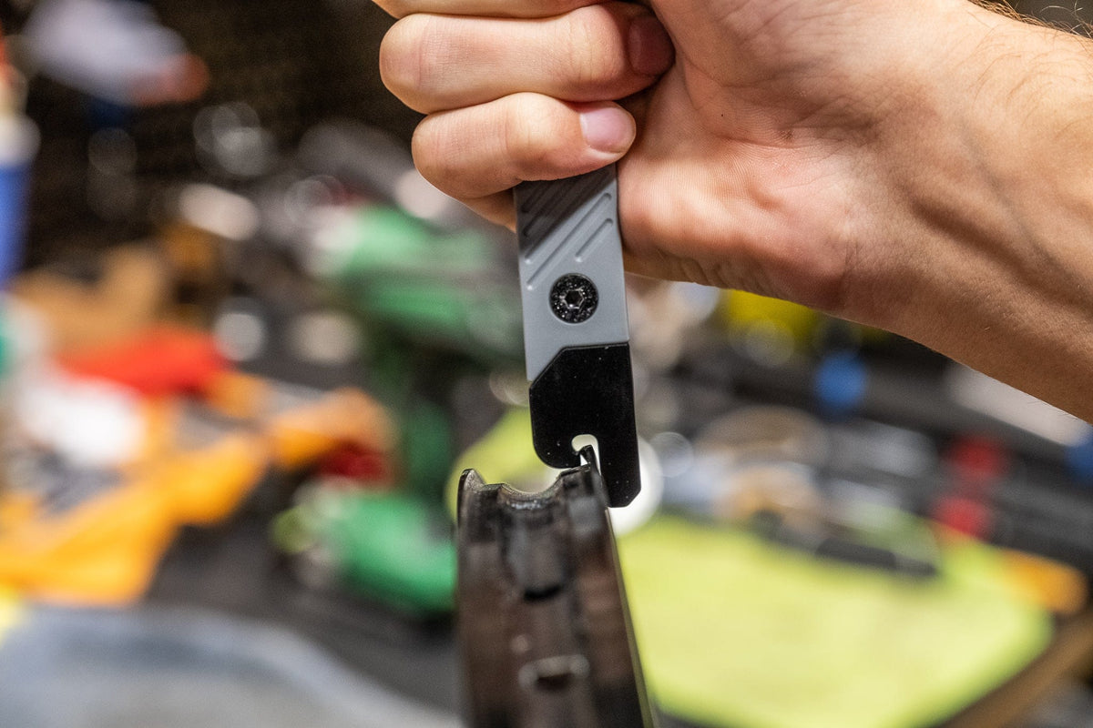 Wolf Tooth 8-Bit Tire Lever + Rim Dent Remover, lever held over a tire in the workshop