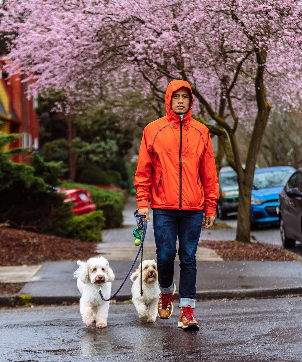 Men's Syncline CC Jacket, orange, hood up, walking dogs on a wet street
