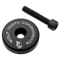 Wolf Tooth ultralight stem cap in black with the Wolf Tooth logo, shown with its bolt