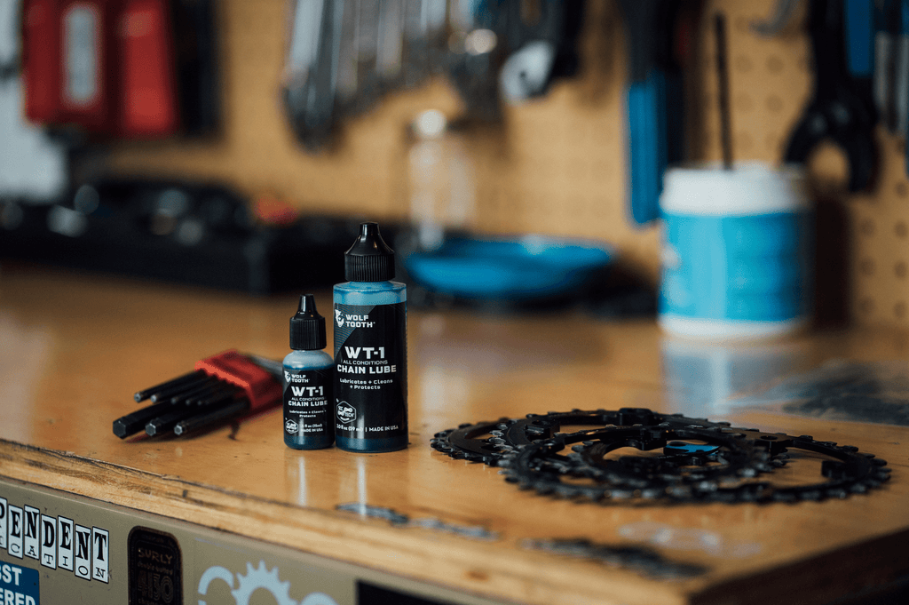 Wolf Tooth WT-1 Chain Lube, two bottle sizes on a workshop bench
