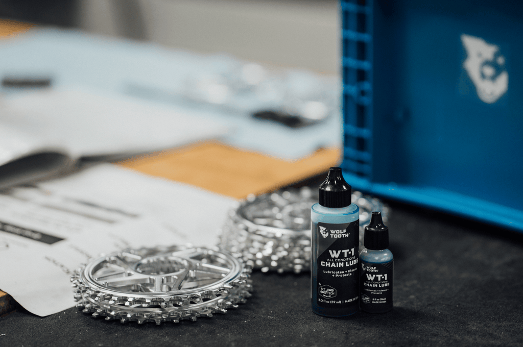 Wolf Tooth WT-1 Chain Lube, two bottle sizes next to chainrings