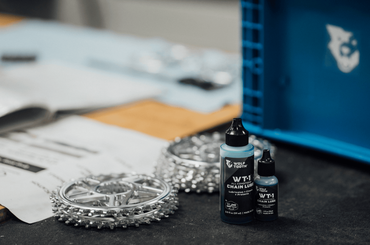 Wolf Tooth WT-1 Chain Lube, two bottle sizes next to chainrings