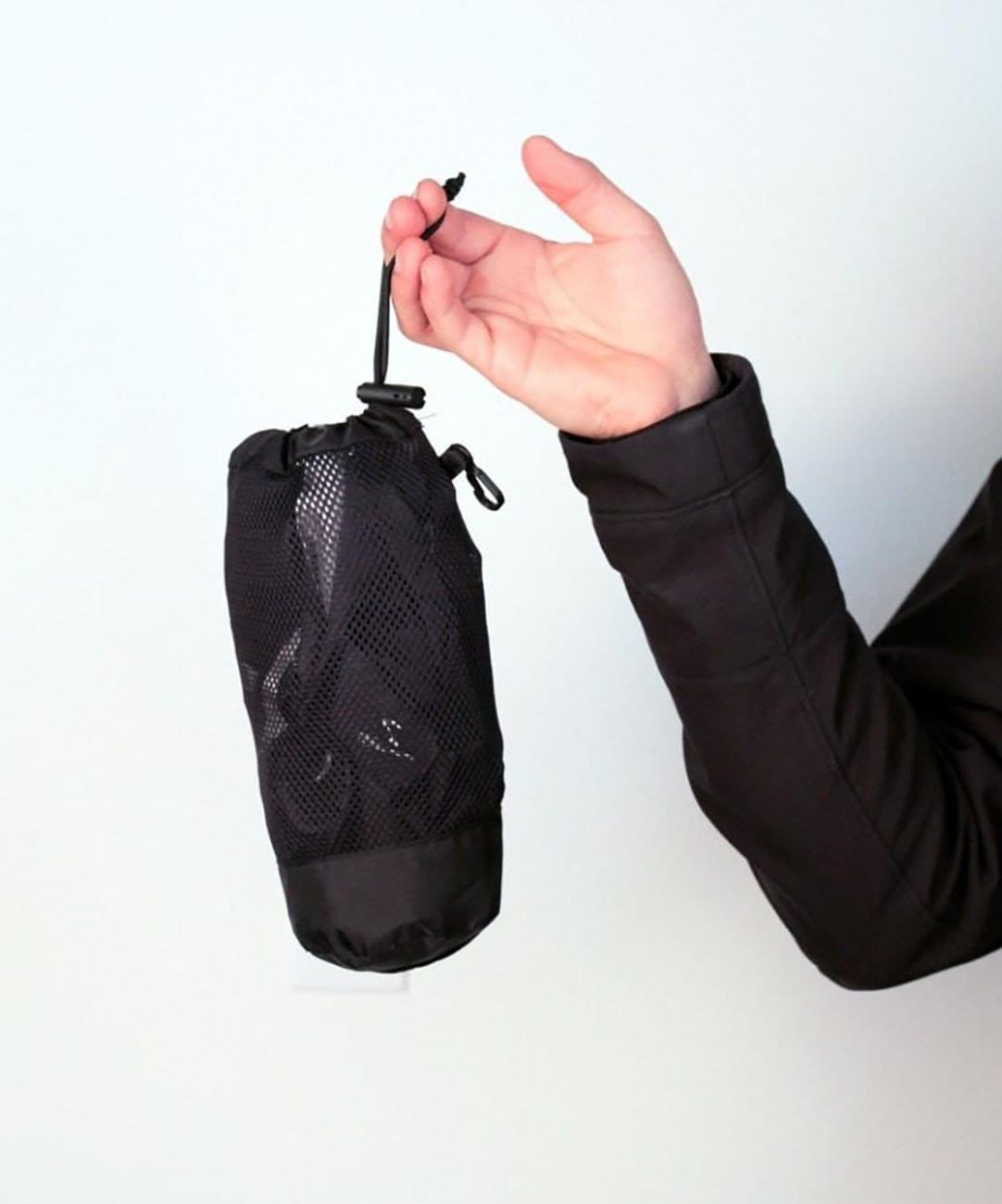 Men's Transit Pant, packed into its stuff sack, held in one hand