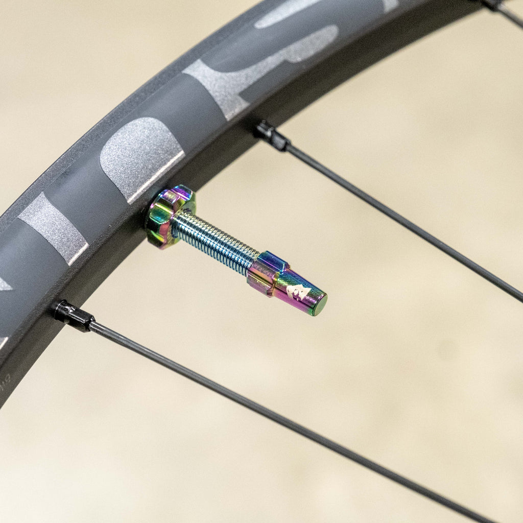 Wolf Tooth Tubeless Presta Valve Stem Kit, oil slick finish, installed on a rim