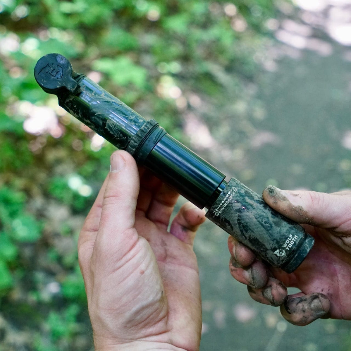 Wolf Tooth EnCase Pump 40cc, muddy pump held in two hands