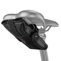 KOM saddle roll in black, strapped under a silver saddle on a seatpost