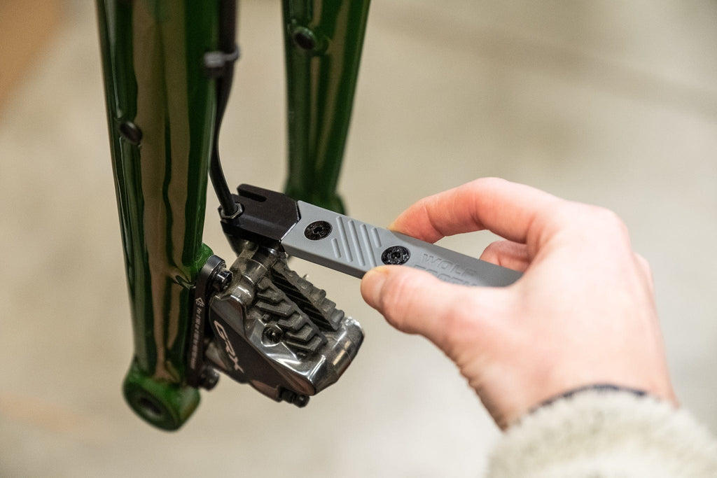 Wolf Tooth 8-Bit Tire Lever + Disc Brake Tool, spreading disc brake pads with the tool
