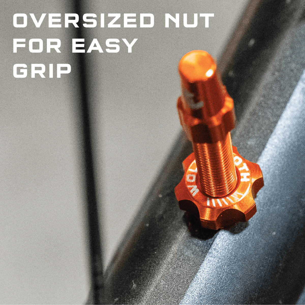 Wolf Tooth Tubeless Presta Valve Stem Kit, orange, close-up of the oversized nut
