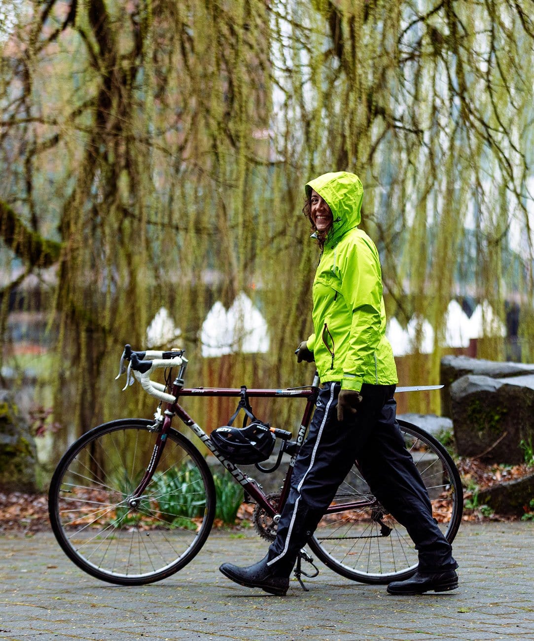 Women's Transit Pant, worn with a hi-vis jacket, walking next to a bike