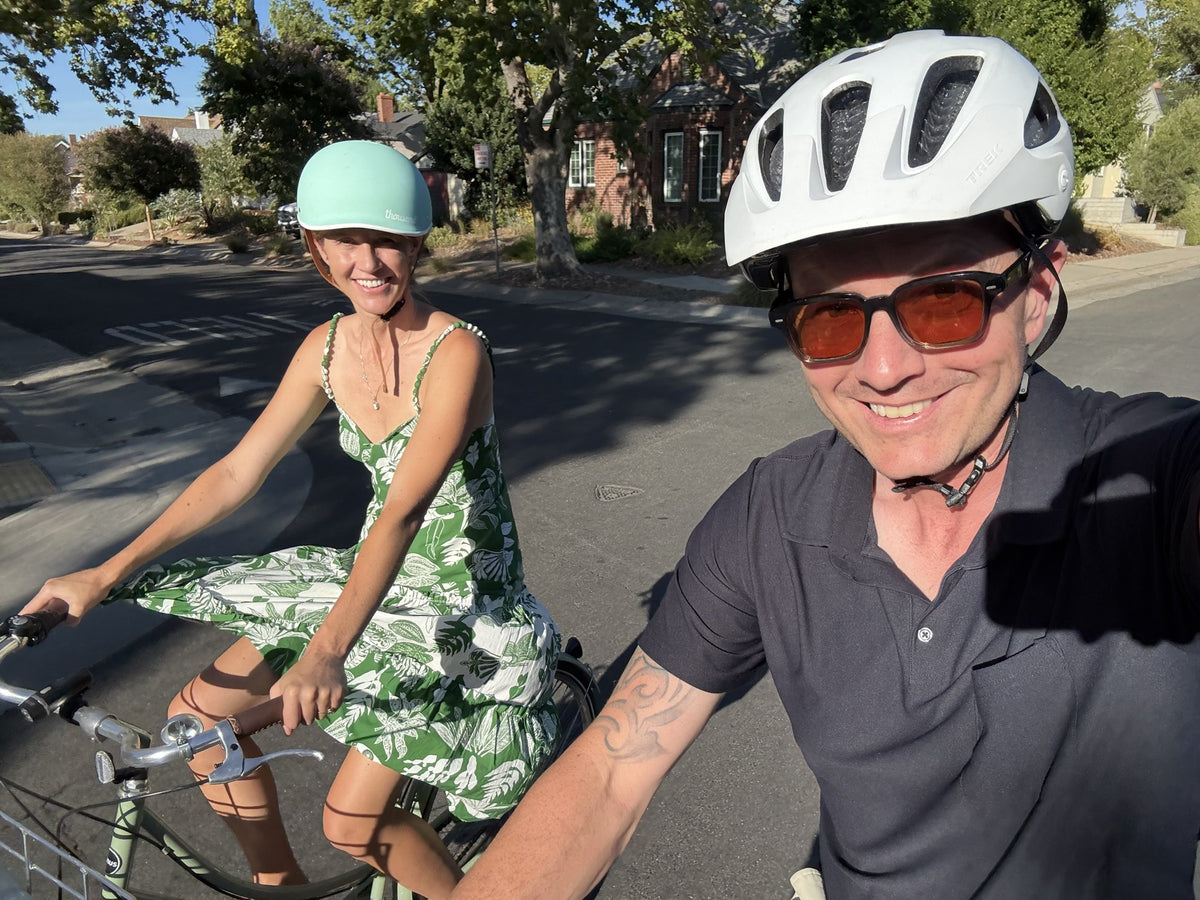 Joe and another rider on a tree-lined neighborhood street, both in helmets