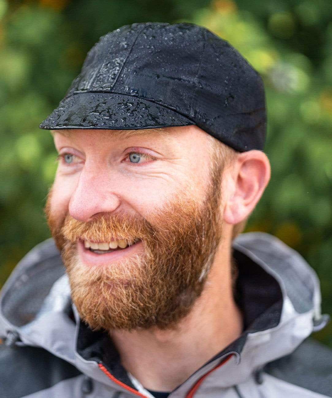 Elite Cycling Cap, black, worn by a smiling rider with water beading on it