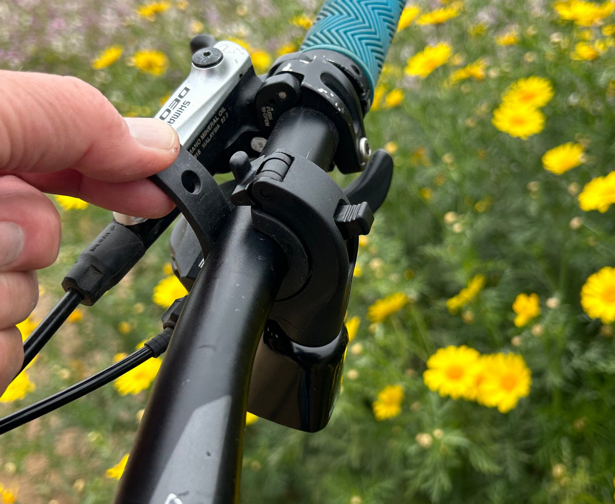 Timber Model Yew! Quick Release Trail Bell, being mounted on a handlebar by hand