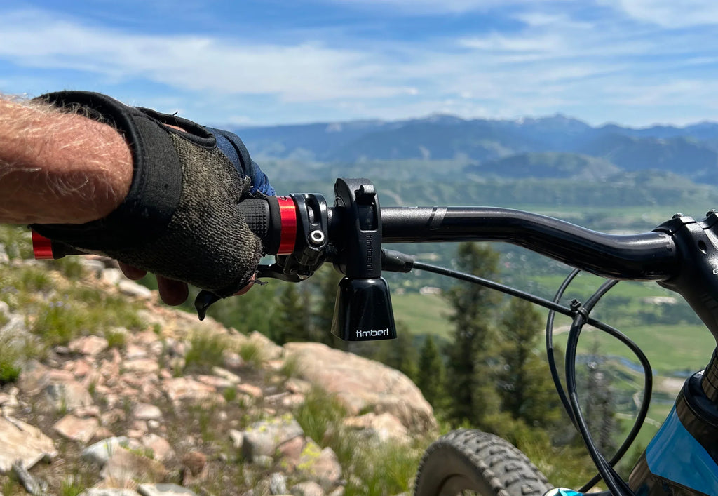 Timber Model Yew! Quick Release Trail Bell, in use on a mountain bike above a valley